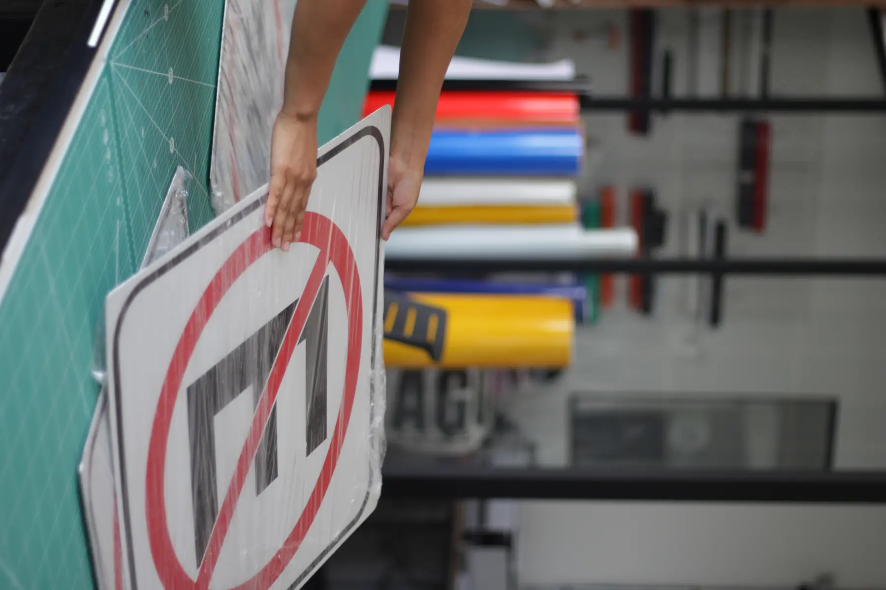 Señal restrictiva circular terminada y envuelta para envío, sobre la mesa de trabajo del taller de Nyne Print